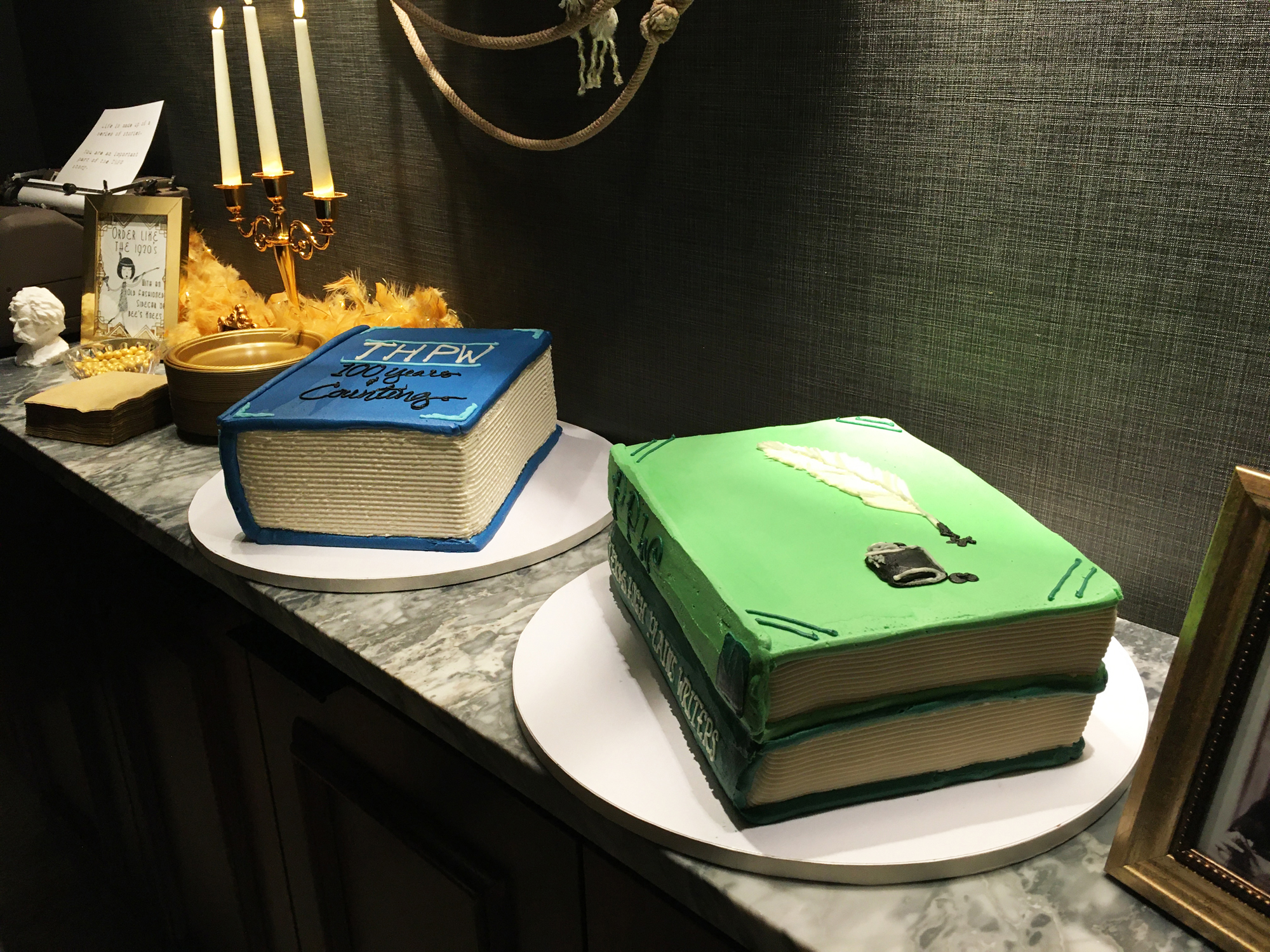 Book cakes with vintage library themed decor that includes a typewriter, a candelabra, and a writer's bust.